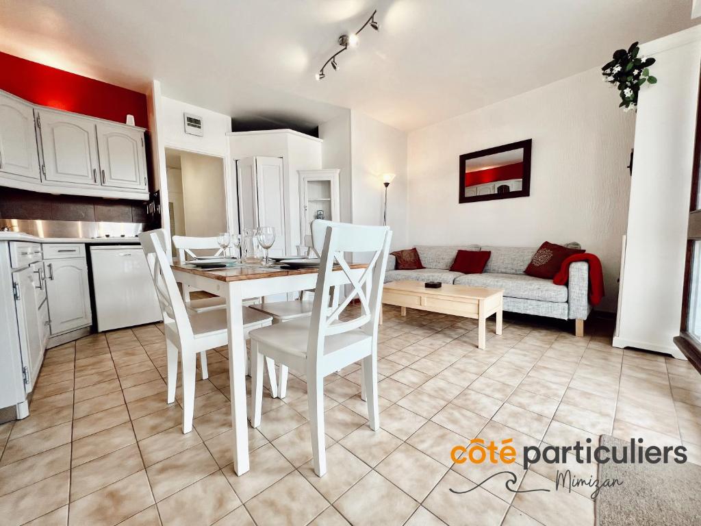 a kitchen and living room with a table and chairs at AU PETIT LOGIS - Apt T1 Bis avec terrasse à 500m de l'Océan in Mimizan