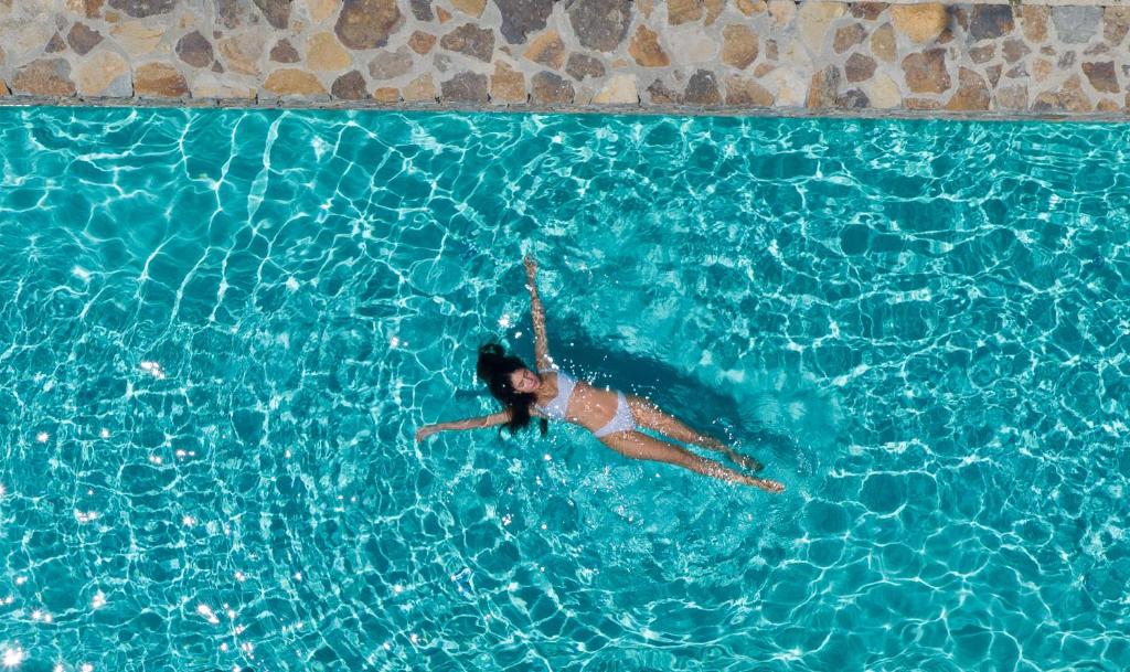 uma mulher está nadando em uma piscina em Korfi de Milo em Adamas