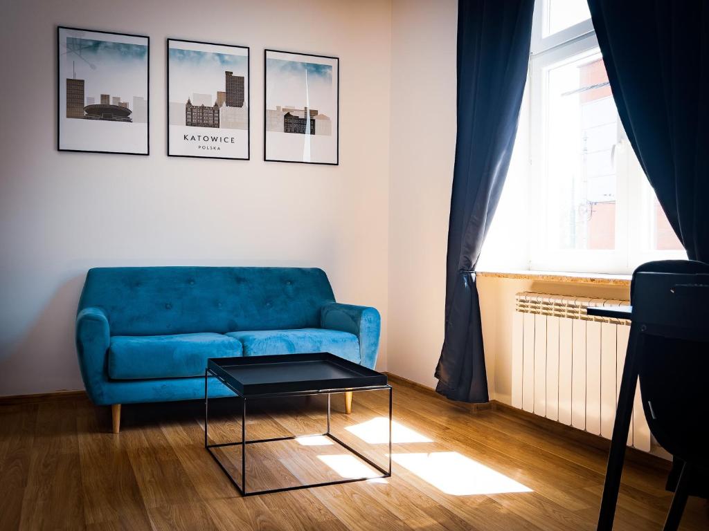 un soggiorno con divano blu e tavolo di Black&White Apartment 8 a Katowice