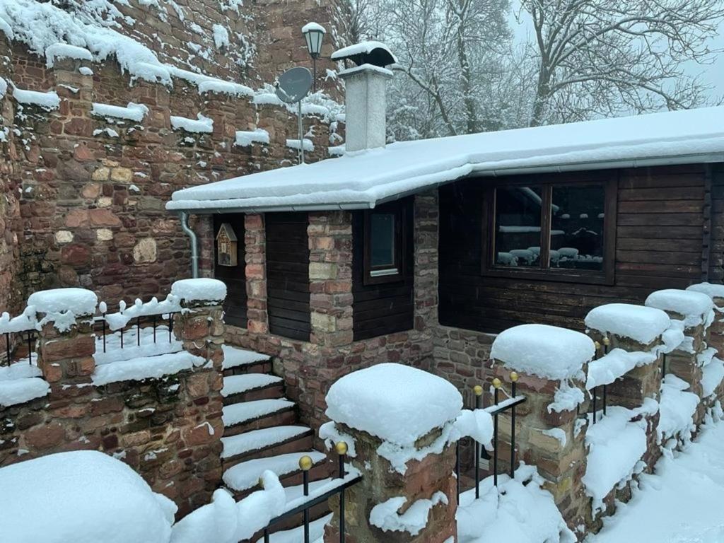 uma casa coberta de neve com neve nas escadas em Holzhäuschen em Nideggen