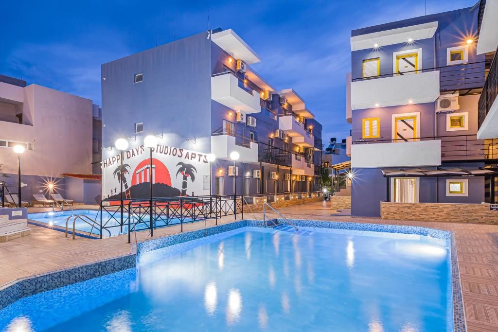 a swimming pool in front of a building at Happy Days in Malia