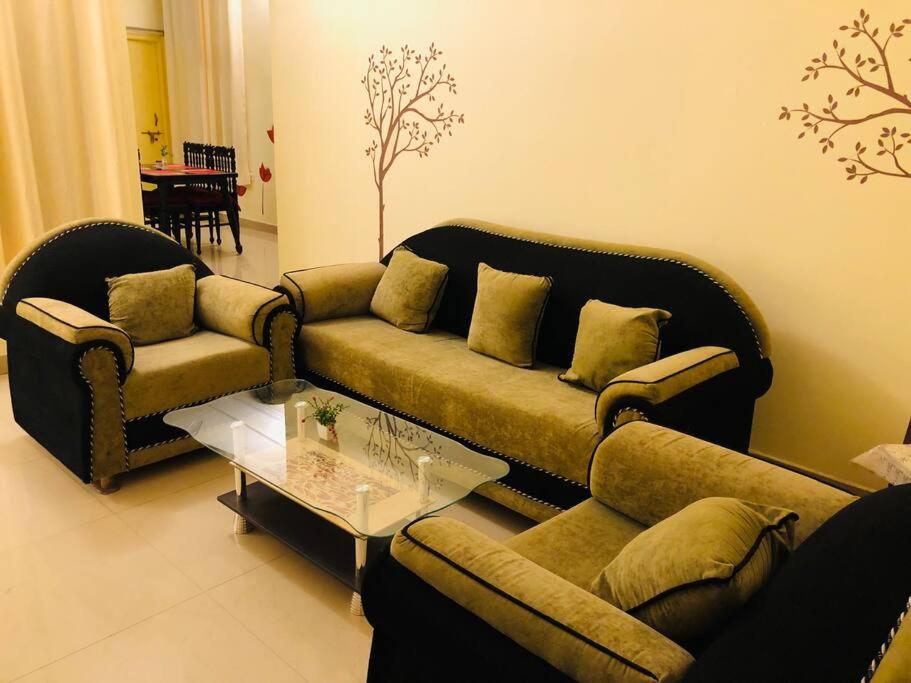 a living room with two couches and a coffee table at The Emerald House in Varanasi
