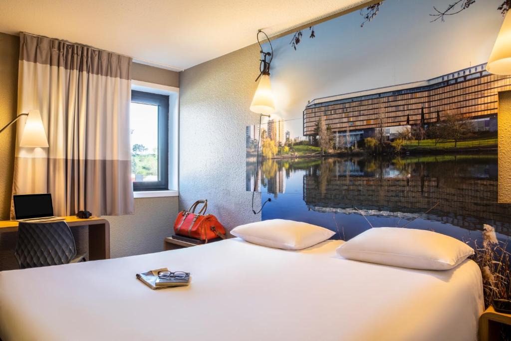 une chambre d'hôtel avec un lit orné d'une peinture murale. dans l'établissement ibis Paris Creteil, à Créteil
