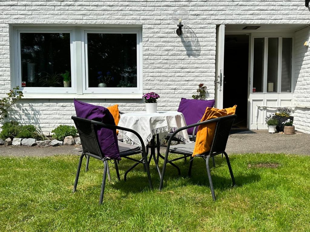 2 chaises et une table en face d'une maison dans l'établissement Rymlig lägenhet i Stenungsund, à Stenungsund
