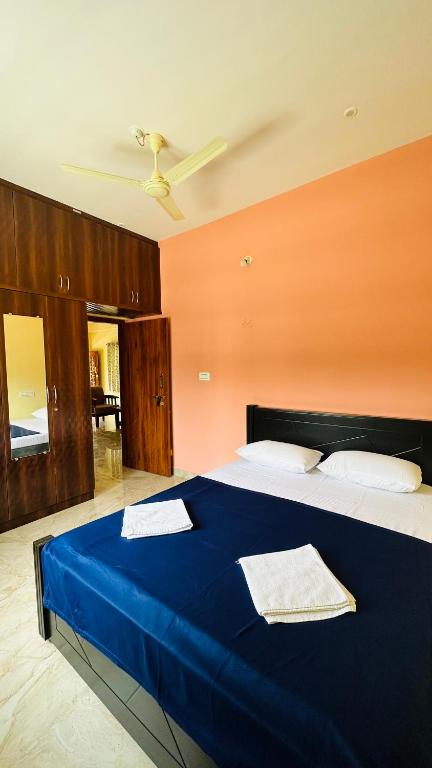 Schlafzimmer mit einem großen blauen Bett und einer Decke in der Unterkunft Navile Apartments in Chikmagalur
