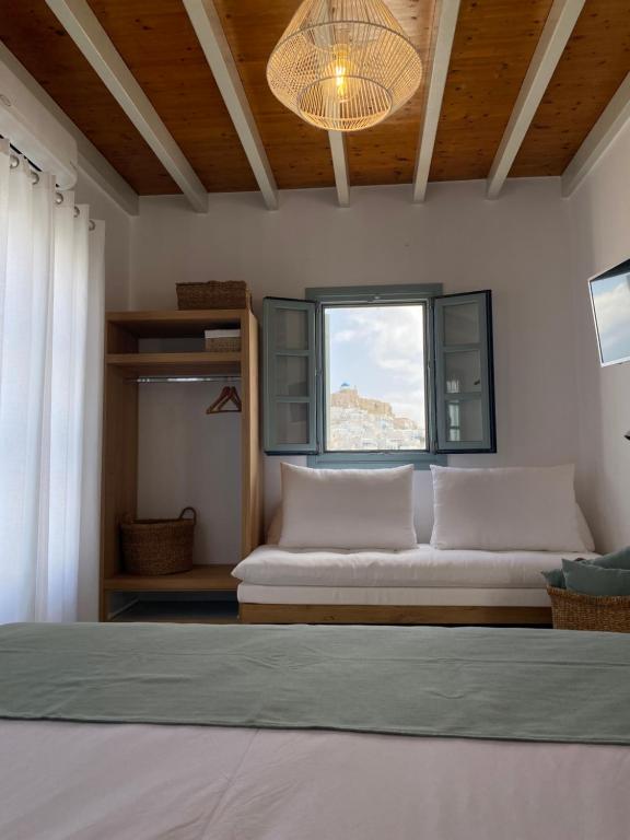 1 dormitorio con cama, ventana y sofá en Arhodiko Studios, en Astipalea