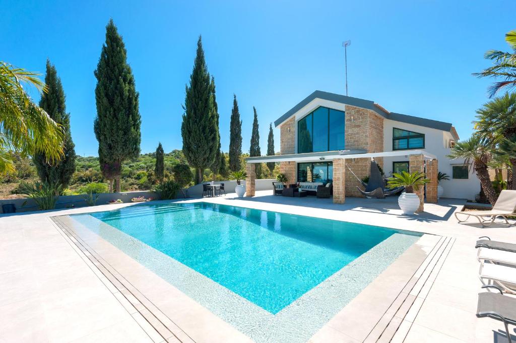 a villa with a swimming pool in front of a house at Villa Heaven in Protaras