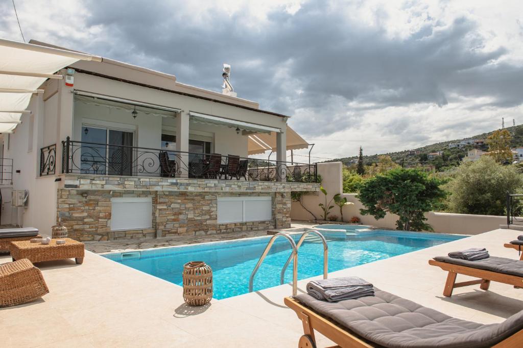 a villa with a swimming pool and a house at NisoVillas in Volos