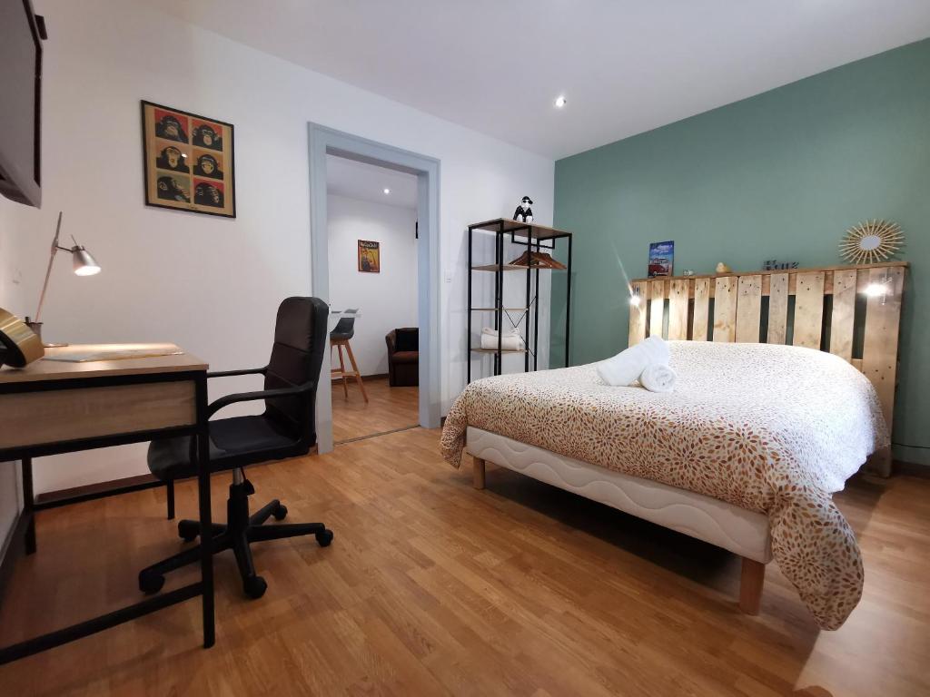 Schlafzimmer mit einem Bett, einem Schreibtisch und einem Computer in der Unterkunft Cosy room - centre ville - 2 pers in Sarreguemines