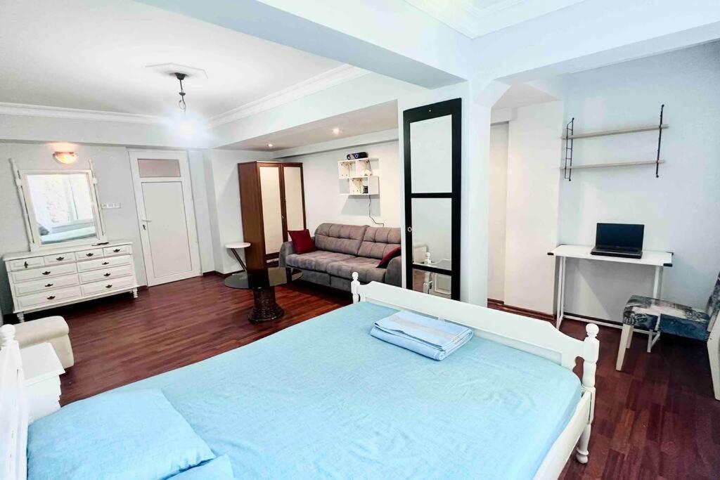 1 dormitorio con cama y sofá en Stylish&Luxury Flat with Garden Close to Sea en Finike