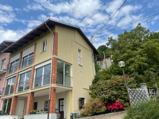 een geel huis met een balkon in een straat bij La Casetta Gialla in Biella