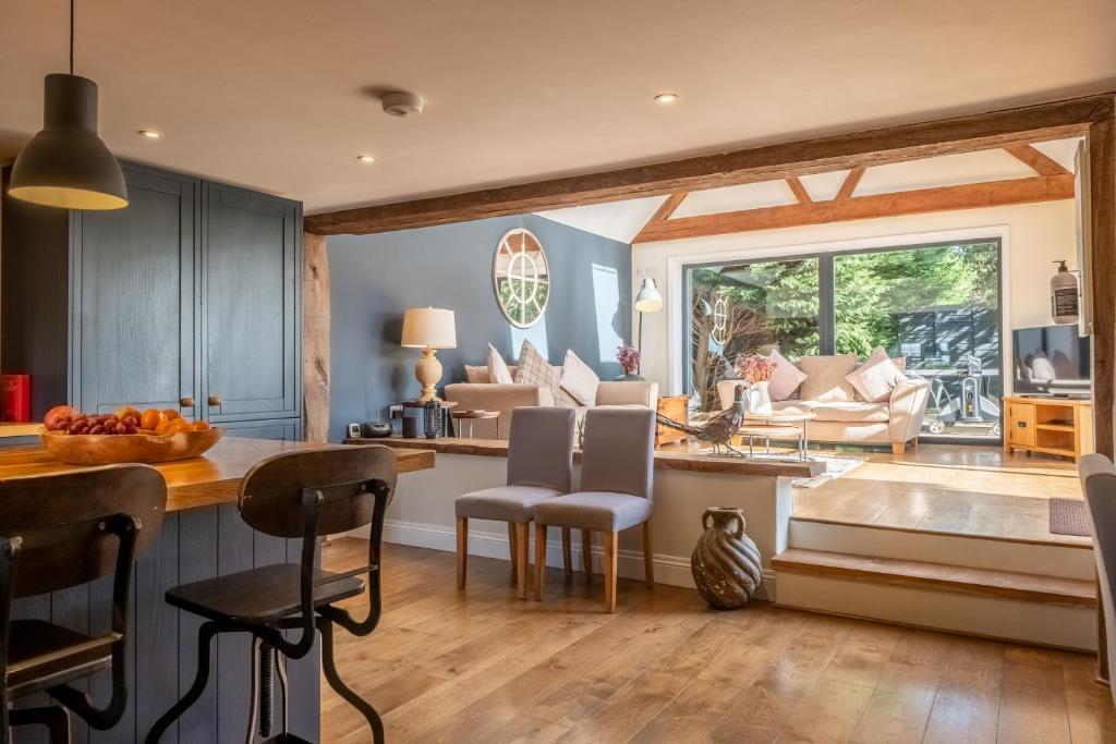 eine Küche mit einem Tisch und Stühlen sowie ein Wohnzimmer in der Unterkunft Heath Cottage in Mattishall