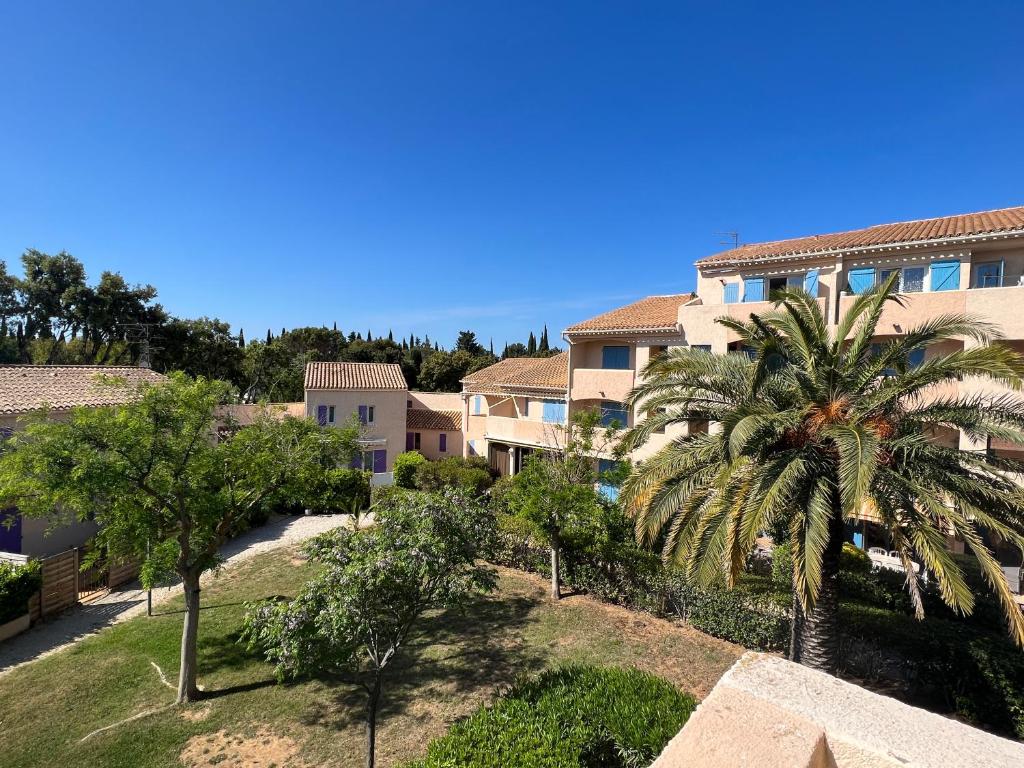 un palmier devant un bâtiment dans l'établissement 4 personnes au Village de la mer, à La Londe-les-Maures