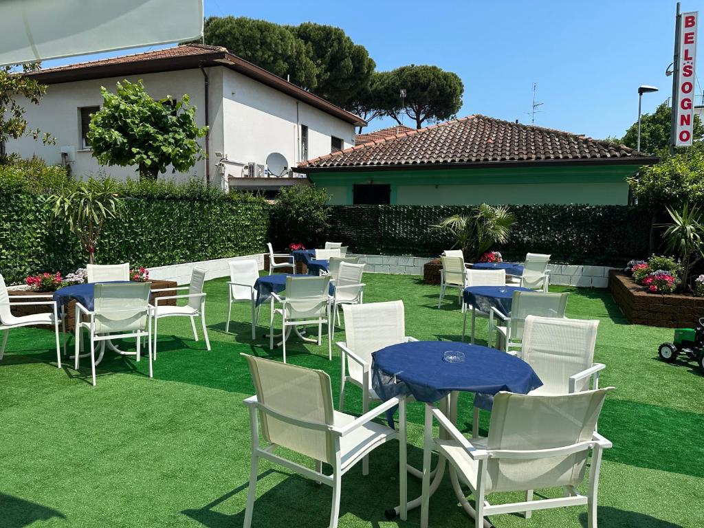 een groep stoelen en tafels op het gras bij Hotel Bel Sogno in Rimini