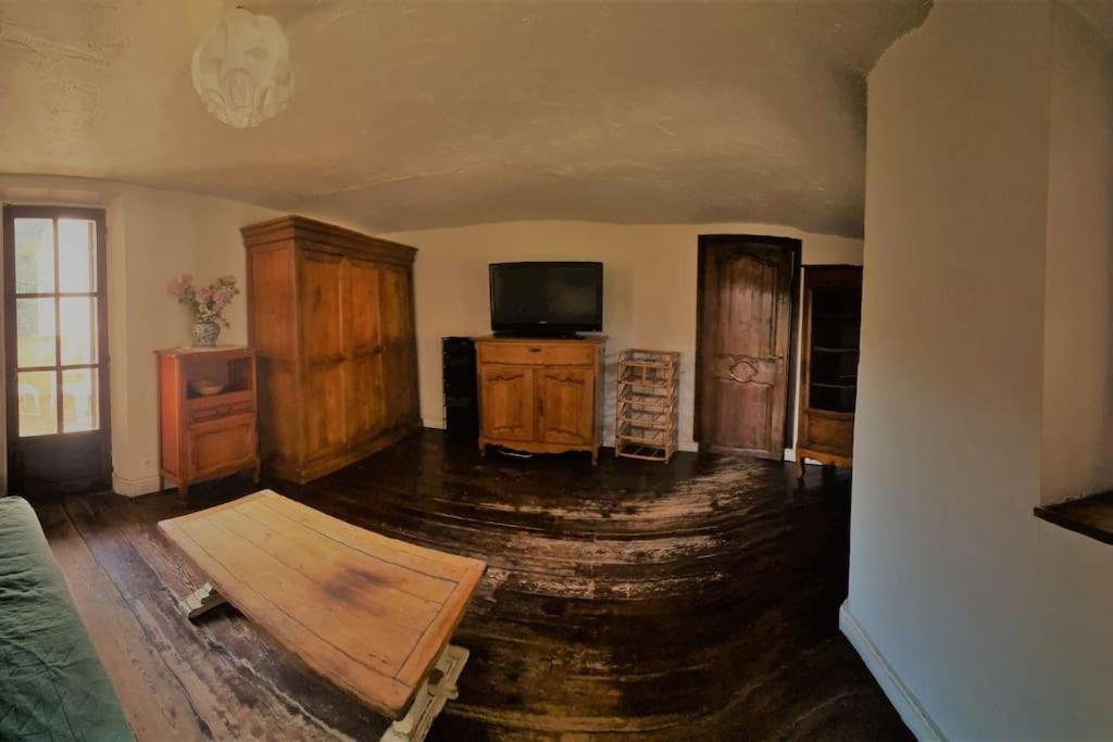 sala de estar con suelo de madera y TV en Gite le mandarinier, en Gourdon