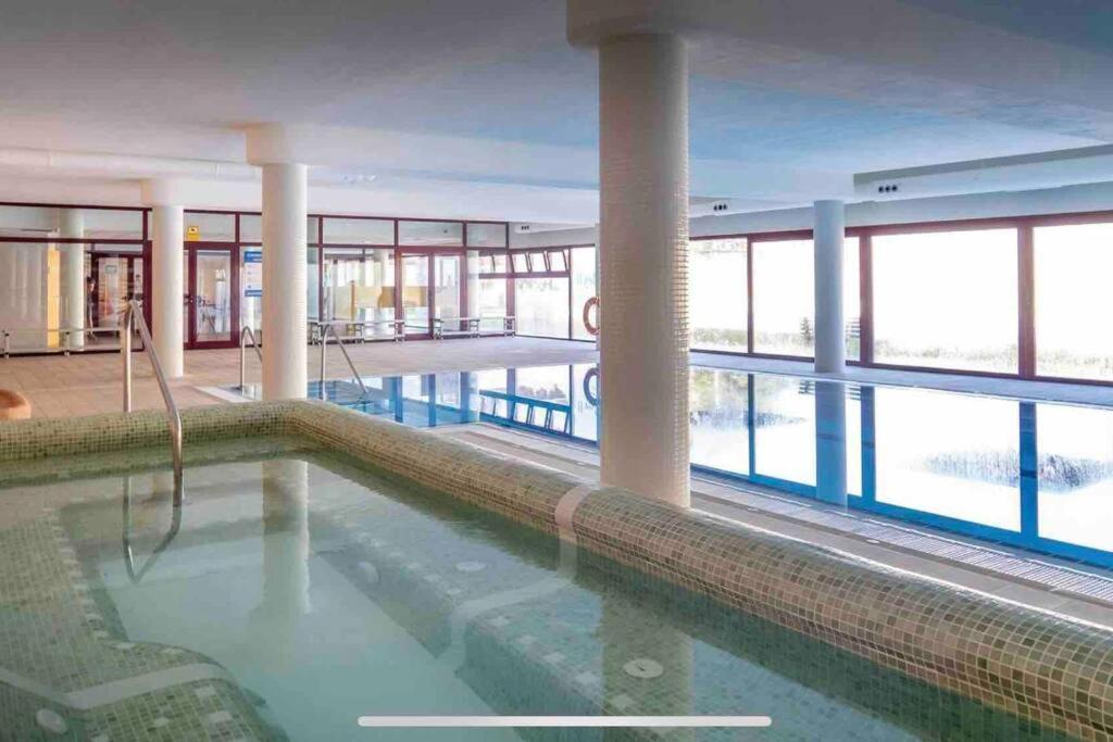 a swimming pool in a building with a large window at Apartamento Natur Spa in Villanueva de Río Segura