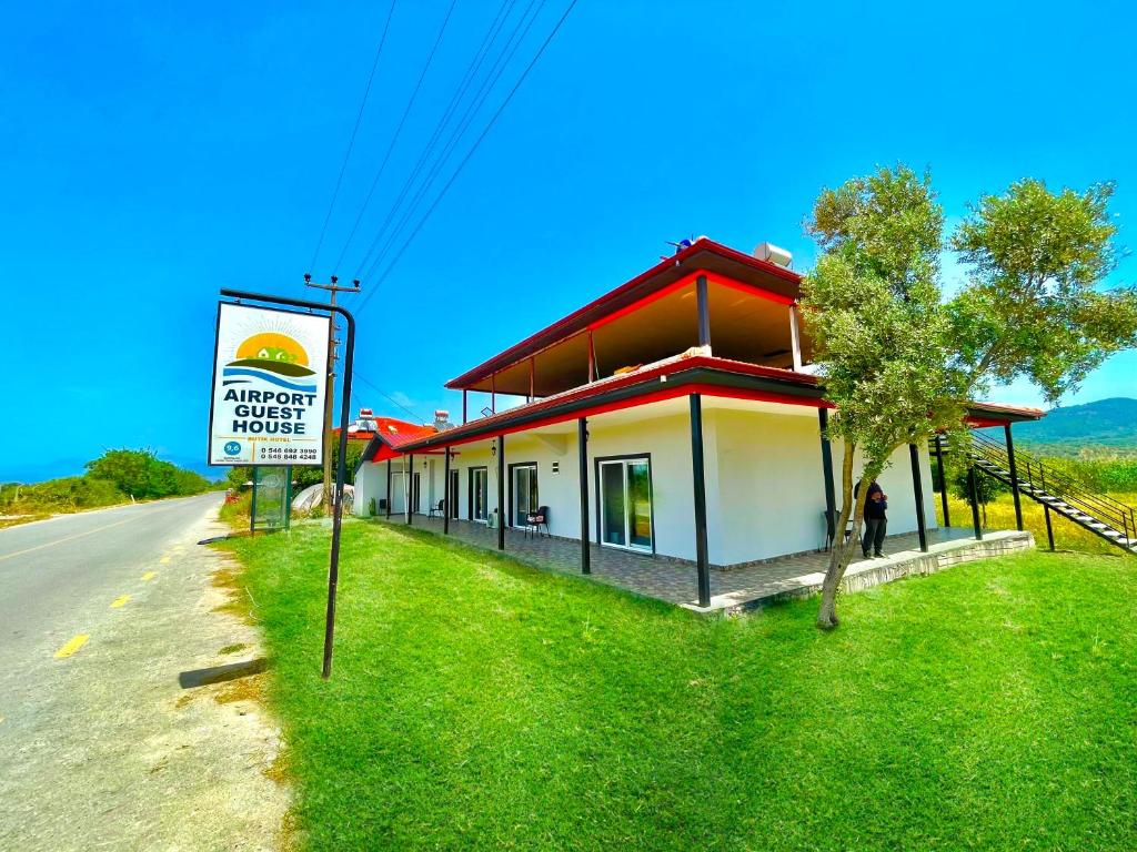 a building on the side of a road with a sign at Airport Guest House in Dalaman