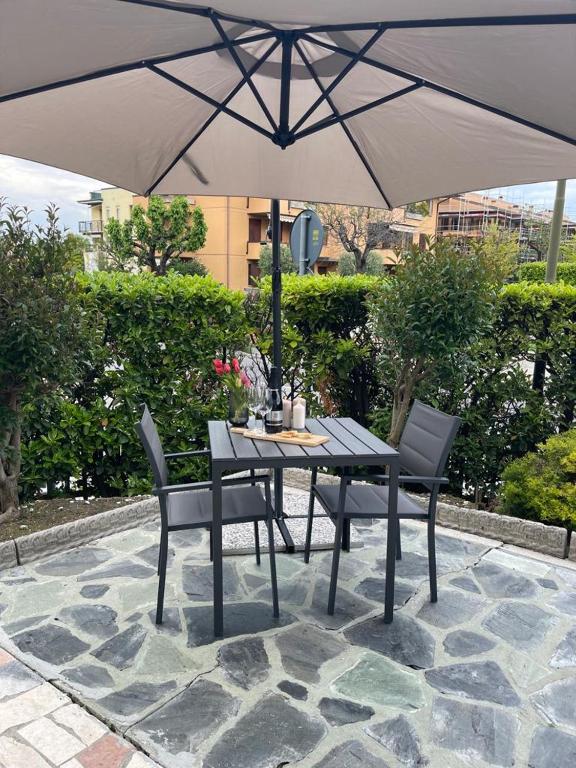 a table and chairs under an umbrella on a patio at La Mirage in Desenzano del Garda