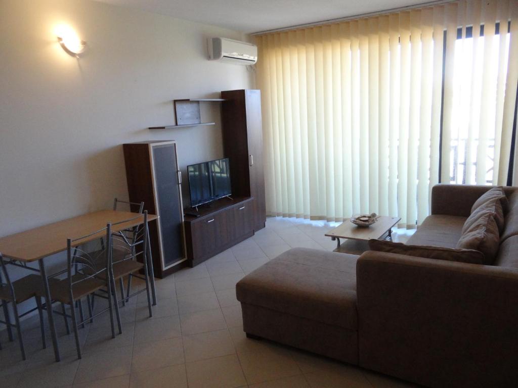 a living room with a couch and a table at Oasis Beach Home Four in Lozenets