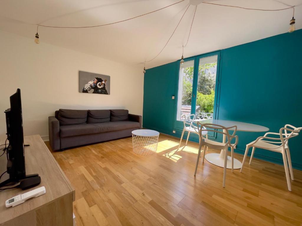 een woonkamer met een bank en een tafel en stoelen bij Laura Cosy T2 *CLIM* Proche Gare in Grenoble