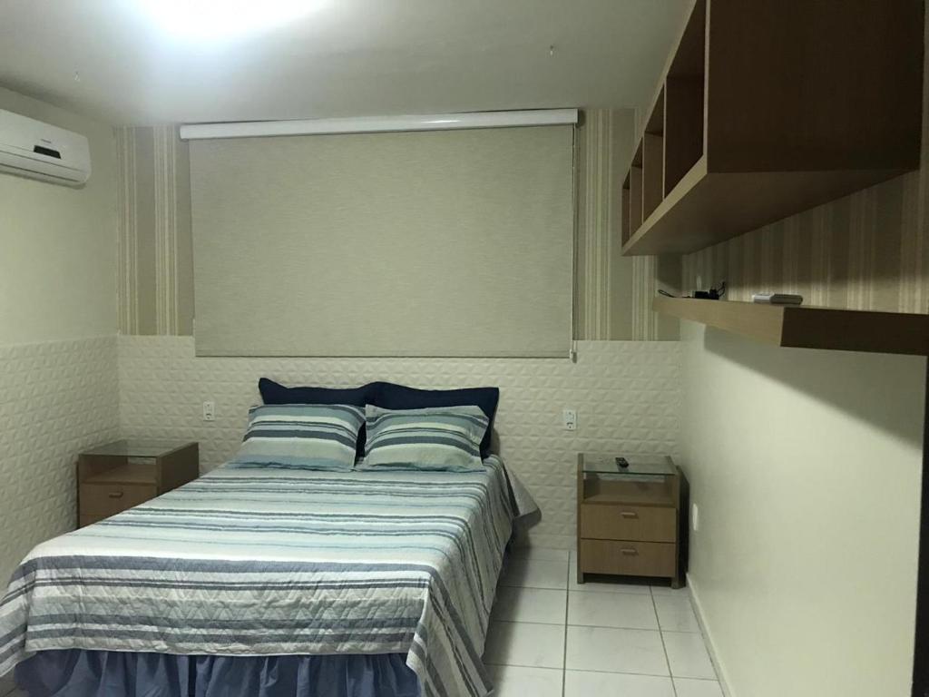 a bedroom with a bed with blue pillows at Excelente casa 300m2 em Bairro Nobre perto de tudo in Natal