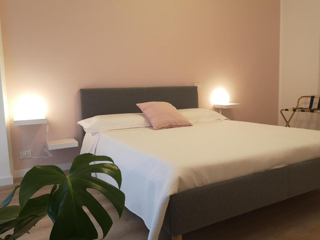 um quarto com uma cama com dois candeeiros e uma planta em So Fine Petruzzelli flat em Bari