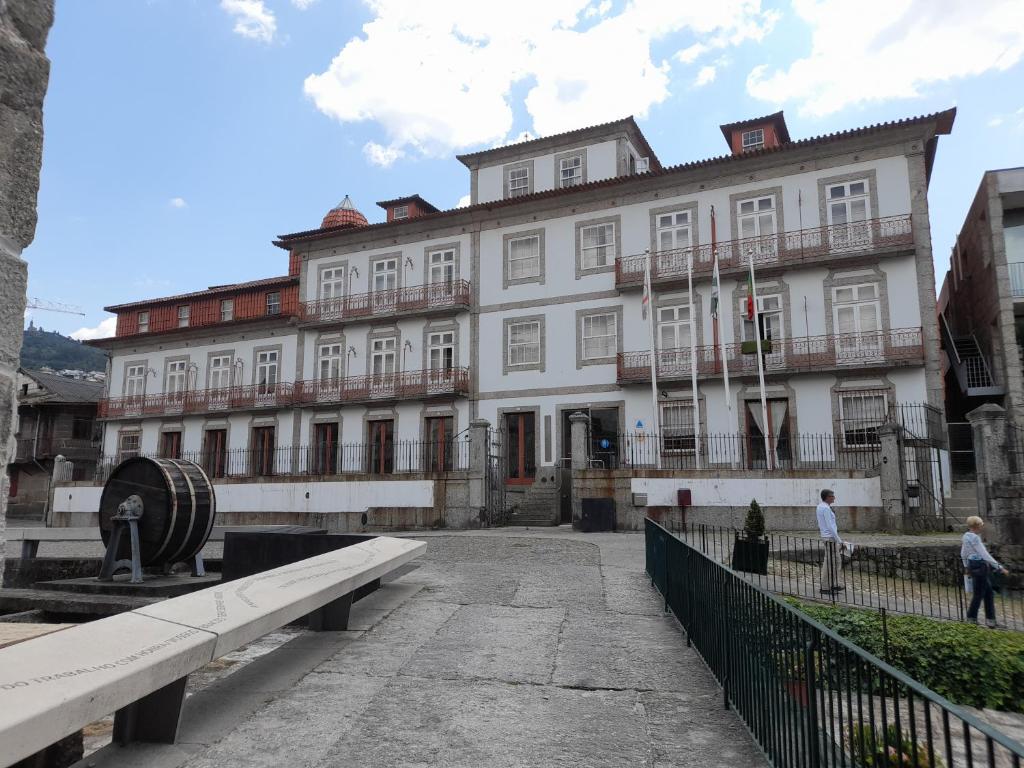 un gran edificio blanco con gente caminando delante de él en HI Guimaraes - Pousada de Juventude en Guimarães
