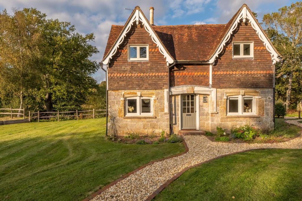 an old brick house with a grass yard at Hensill Farmhouse in Hawkhurst