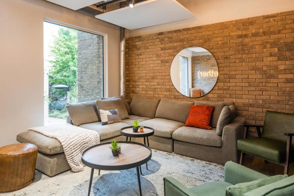 a living room with a couch and a brick wall at For Students Only Modern Studios and Ensuite Bedrooms with Shared Kitchen at Hillfort House in Brighton in Brighton & Hove