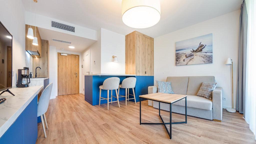 ミエルノにあるApartamenty Magnet Jantarisのソファとテーブルのあるリビングルームとキッチン