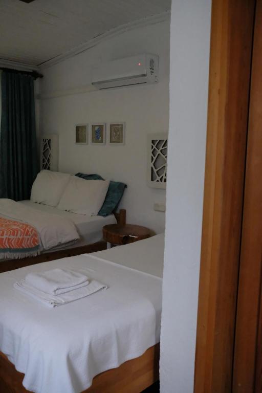 a hotel room with two beds and a window at Ceneviz Hotel in Adrasan