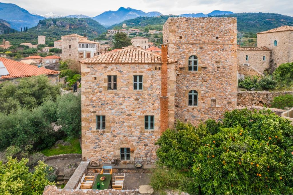 an old stone building with mountains in the background at The Tower House in Kardamyli