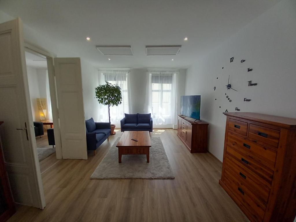 uma sala de estar com um sofá azul e uma mesa em Korvin One Apartman em Pápa