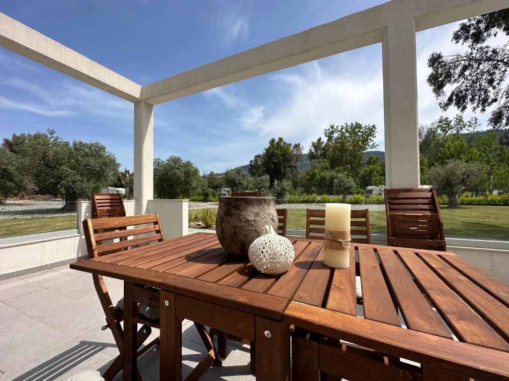 a wooden table and chairs on a patio at Luxury rental villa for 14 people in Vourvourou