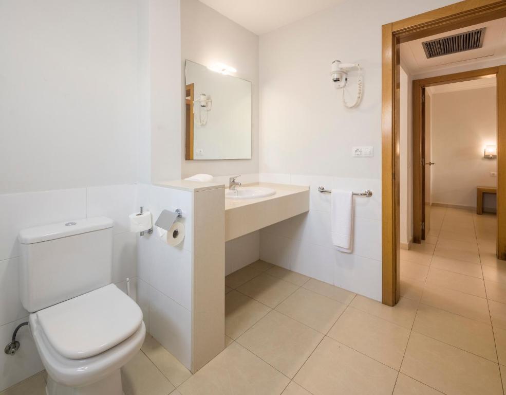 a bathroom with a toilet and a sink and a mirror at ILUNION Costa Sal Lanzarote in Puerto del Carmen
