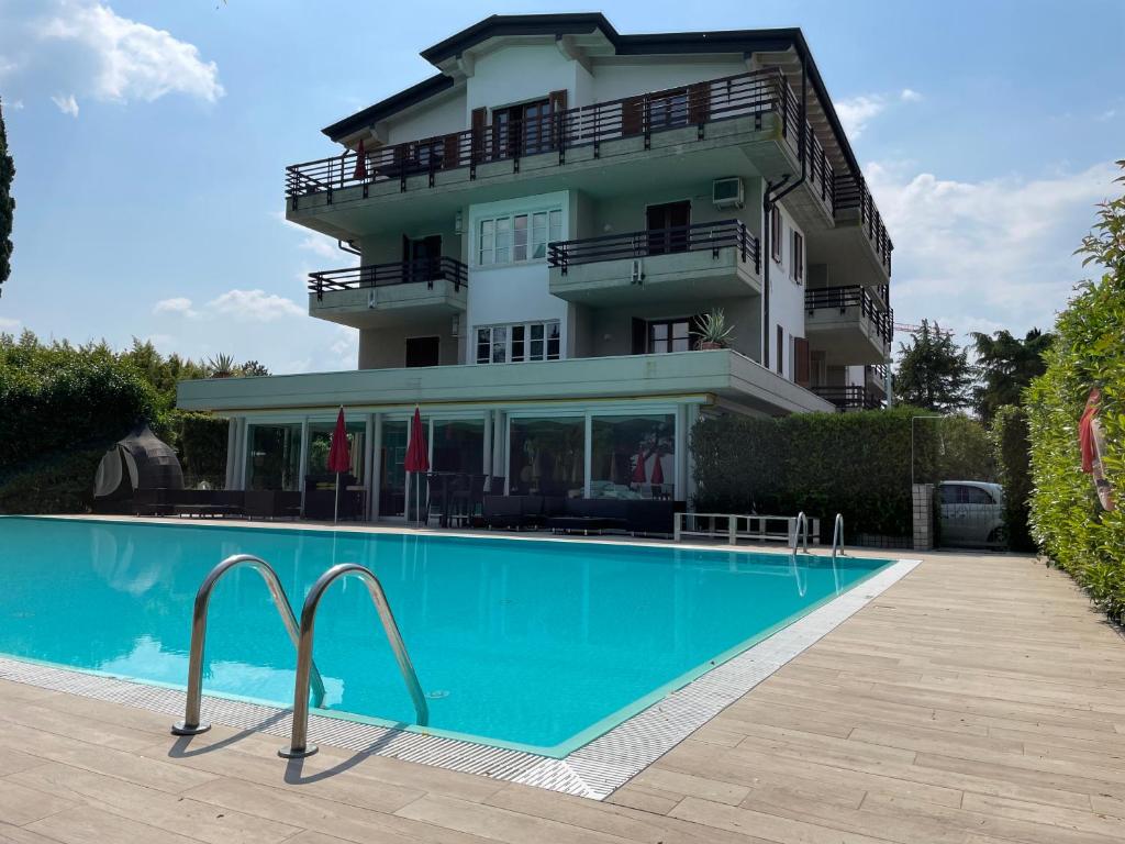 un bâtiment avec une piscine en face d'un bâtiment dans l'établissement Residence Alexandra Stay, à Sirmione