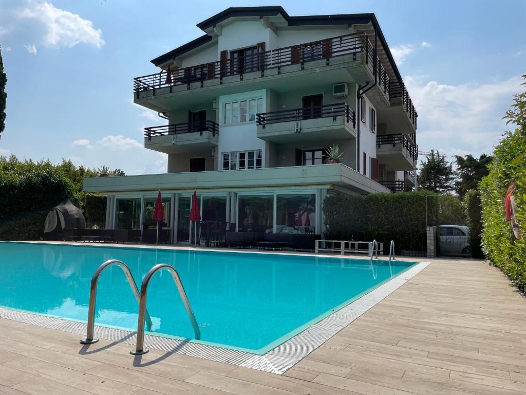 a building with a swimming pool in front of a building at Residence Alexandra Stay in Sirmione