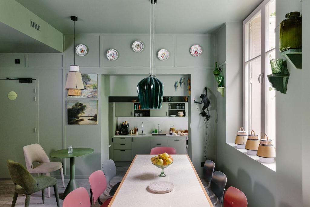 a dining room with a table and chairs and a kitchen at Gogaille - Fernand Rabier - accès autonome in Orléans