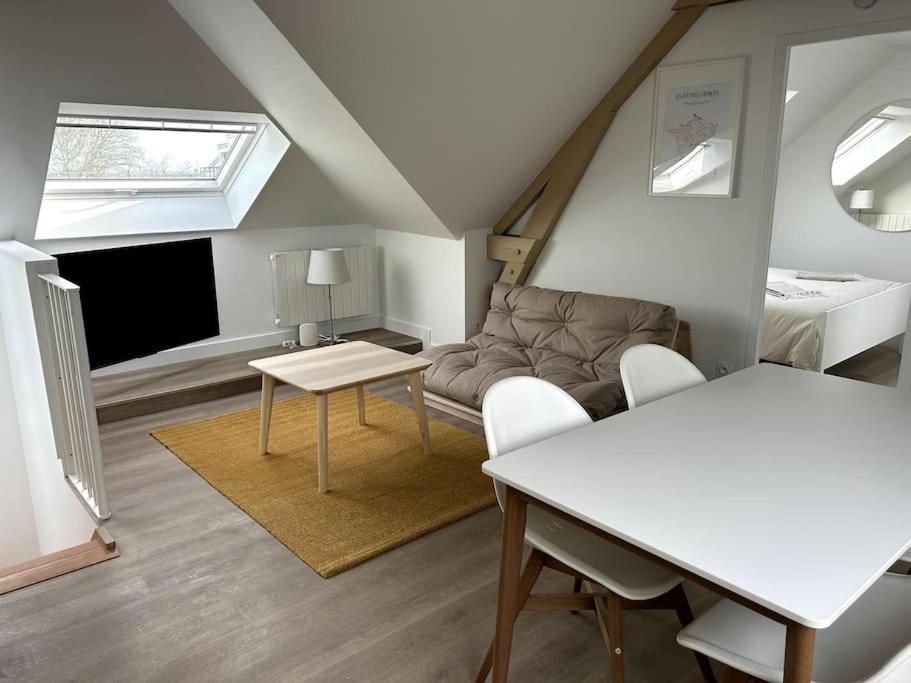 un soggiorno con divano e tavolo di Charmant appartement chez Pat a Caen