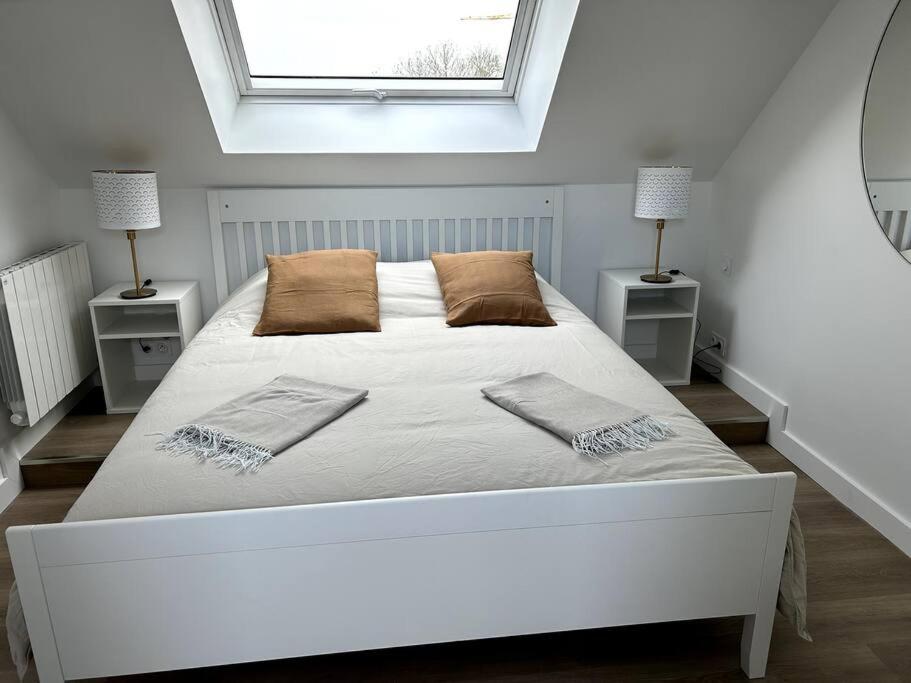 a bedroom with a large white bed with two night stands at Charmant appartement chez Pat in Caen