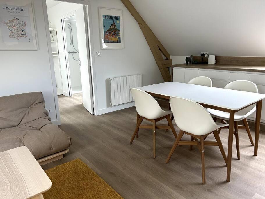 a living room with a table and chairs and a couch at Charmant appartement chez Pat in Caen