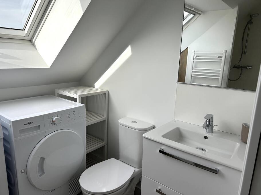 a white bathroom with a toilet and a sink at Charmant appartement chez Pat in Caen