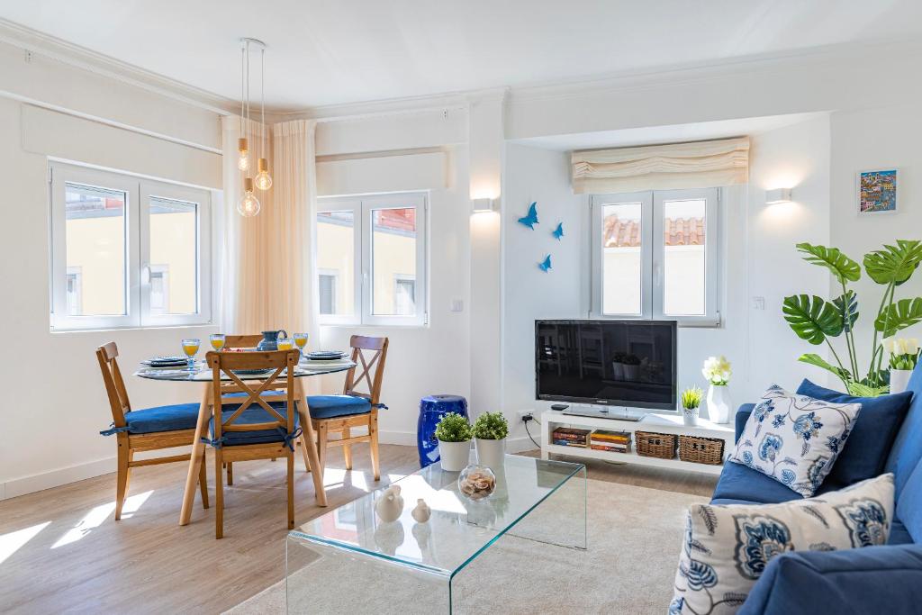 ein Wohnzimmer mit einem blauen Sofa und einem Tisch in der Unterkunft Gia's Homes Cascais by LovelyStay in Cascais