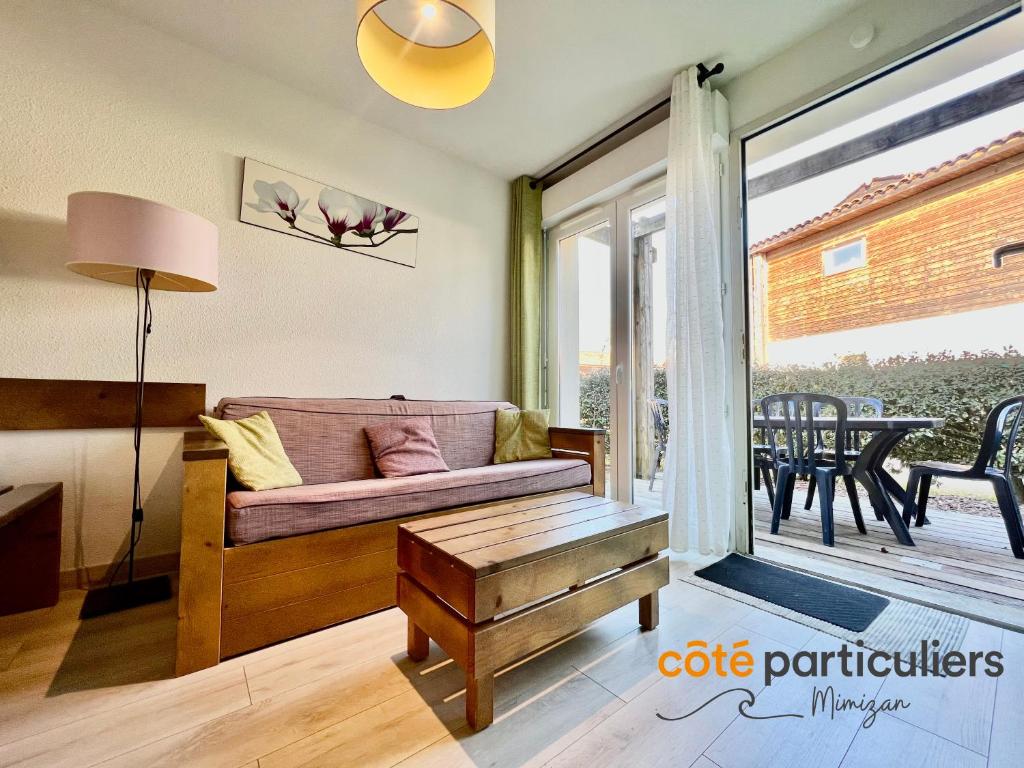 un salon avec un canapé et une table dans l'établissement LES TERRASSES DU LAC 26 - Apt T3 au bord du Lac, à Aureilhan