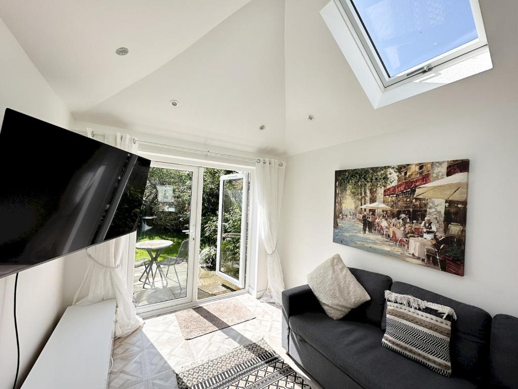 een woonkamer met een zwarte bank en een raam bij Pass the Keys Modern Coastal Cottage in North Shields