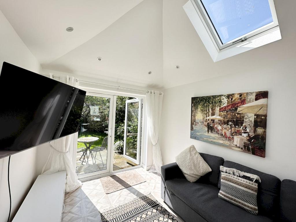 a living room with a black couch and a window at Pass the Keys Modern Coastal Cottage in North Shields