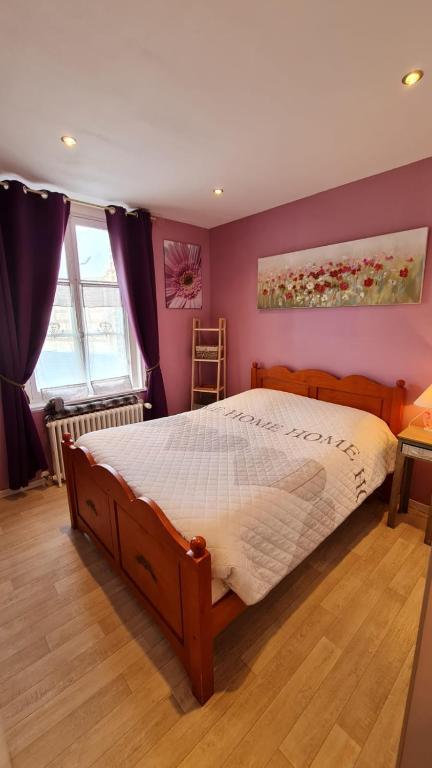 une chambre avec un grand lit aux murs violets dans l'établissement BEL APPARTEMENT CENTRE VEULES LES ROSES 1 CHAMBRE MER 300 M, à Veules-les-Roses