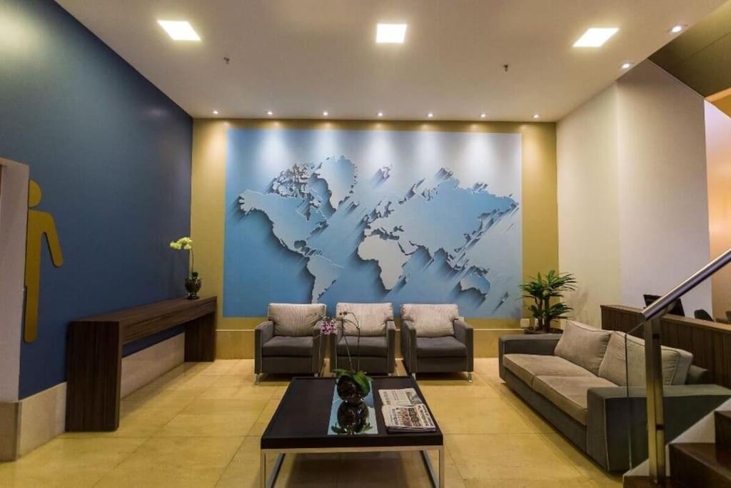 a living room with a map of the world on the wall at Flat Hotel Nobile A18 in Brasilia