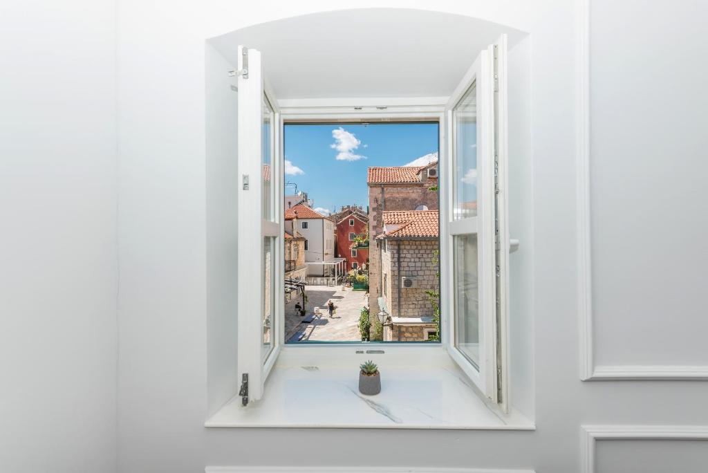 an open window with a view of a city at Palace Heritage Apartments in Makarska