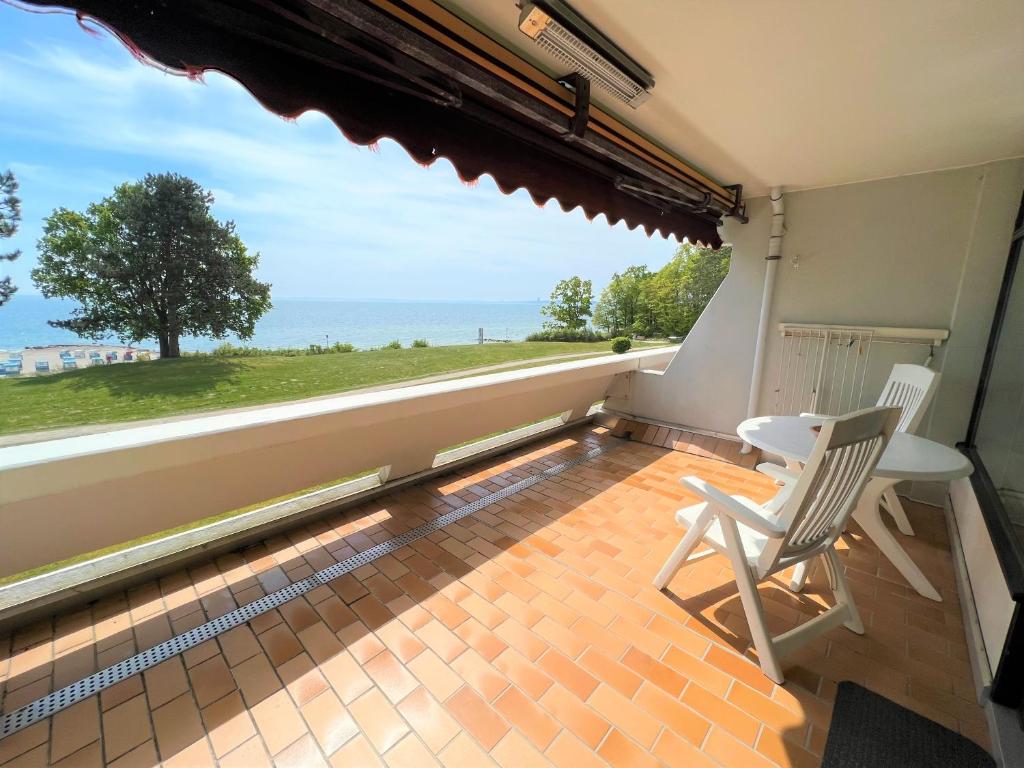 uma varanda com 2 cadeiras e vista para o oceano em Ferienpark Sierksdorf App 53 - Strandlage em Sierksdorf